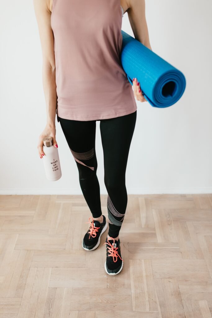 women in gym clothes with a yoga mat